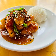 Firefly Restaurant signature dishes Sesame Chicken, Fish Tacos, Spicy Tuna Roll, Lettuce Wraps, Thai Peanut Stir Fry.